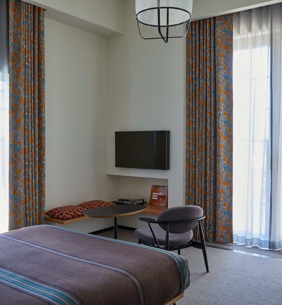 Floor to ceiling windows on each wall provide ample natural light and additional seating in the corner provides space to relax