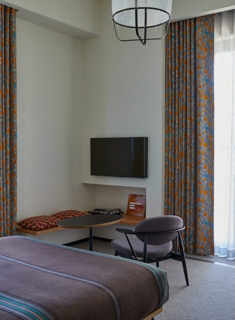 Floor to ceiling windows on each wall provide ample natural light and additional seating in the corner provides space to relax