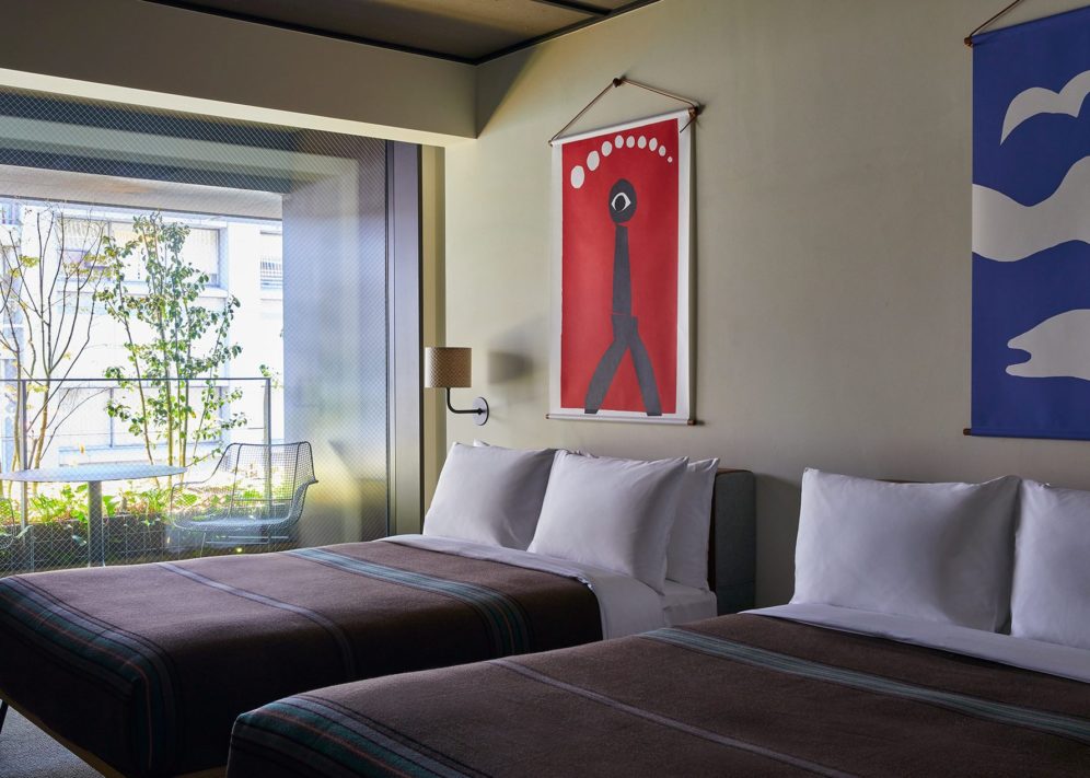 A floor to ceiling transparent door provides access to a balcony overlooking greenery and city sights